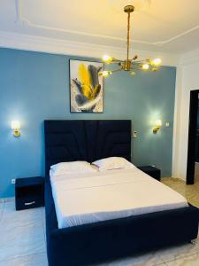 a bedroom with a large bed with a blue wall at Résidence o-calme in Yaoundé