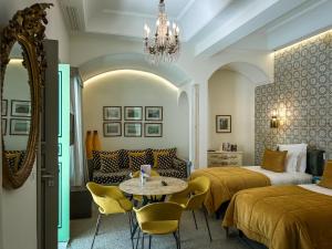 a hotel room with two beds and a table and chairs at Dar Ben Turkia in Tunis +59 photos