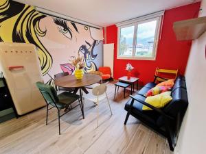 a living room with a couch and a table at Escale Pop Art T3 in Ugine