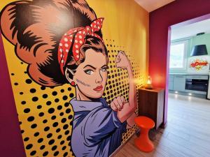 a painting of a woman with a mirror in a room at Escale Pop Art T3 in Ugine