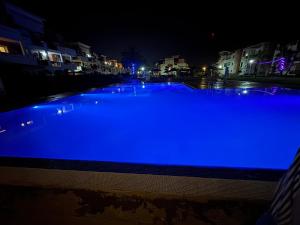 a large blue swimming pool at night at Luxueuse à Marina Saidia in Saïdia