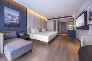 a hotel room with two beds and a couch at Atour Hotel Guangzhou Baiyun Station Julong Metro Station in Guangzhou