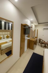 ein Hotelzimmer mit einem Bett und einem Spiegel in der Unterkunft Hotel Aman Grand New Delhi # Mahipalpur # Restaurant, Lift, # Top Rated Property in Delhi