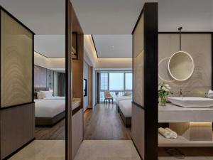 a hotel room with a bathroom and a bedroom at 上海野生动物园荷逸唐酒店-惠南地铁站店 in Nanhui
