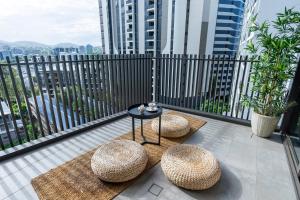 un balcon avec deux tabourets et une table et quelques bâtiments dans l'établissement West End Boutique Apt near South Brisbane & CBD, à Brisbane