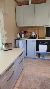 eine Küche mit weißen Schränken und einer weißen Arbeitsplatte in der Unterkunft Grandma's cottage in Sotkamo + 7 Fotos