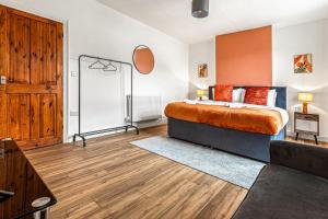 ein Schlafzimmer mit einem Bett und einem Holzboden in der Unterkunft Superking Beds, Smart TVs, Gigabit WiFi, Sleeps 6 in Derby