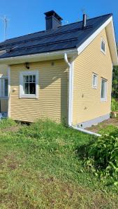 ein gelbes Haus mit einem Seitenfenster in der Unterkunft Grandma's cottage in Sotkamo