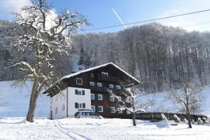 ein Gebäude im Schnee mit einem Auto daneben. in der Unterkunft Appartement Sandra in Schruns-Tschagguns