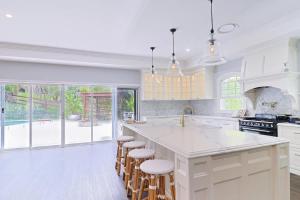 une cuisine blanche avec un grand îlot avec des tabourets de bar dans l'établissement King Beds - Ensuites - Sleeps 20 - Cinema - Lake, à Neranwood 23 autres photos