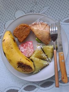 a plate of food with a banana and other foods at Merapi Hotel Backpacker in Yogyakarta +8 photos