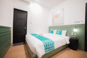 a bedroom with a bed with green and white at Ubu Villa California - 2 Bedrooms Villa in Yogyakarta in Sleman
