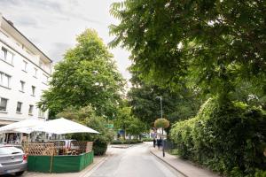a street with trees and an umbrella on a sidewalk at Rob's Place - Ruhige 2-Zi-City-Oase mit Panorama über den Weberplatz in Essen