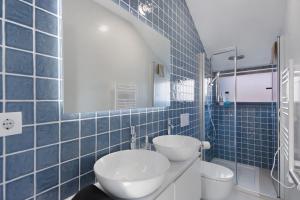 a blue tiled bathroom with a toilet and a sink at Flor de Sá in Aveiro +13 photos