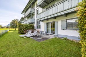 a house with two chairs and a table in the yard at Fewo Brünnstein - Nr 13 Pool, Sauna in Oberaudorf