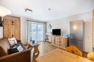 a living room with a couch and a refrigerator at Fewo Brünnstein - Nr 27 Pool, Sauna in Oberaudorf