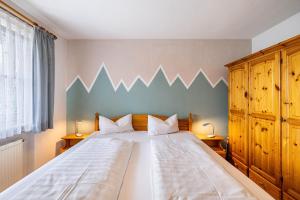 a bedroom with a large bed with a blue wall at Fewo Brünnstein - Nr 27 Pool, Sauna in Oberaudorf