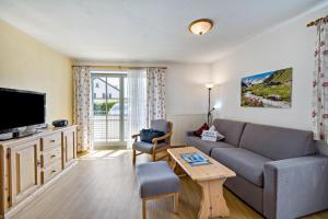 a living room with a couch and a tv at Fewo Brünnstein - Nr 5 Pool, Sauna in Oberaudorf