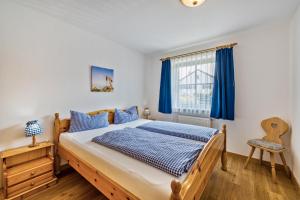 a bedroom with a bed and a window with blue curtains at Fewo Brünnstein - Nr 5 Pool, Sauna in Oberaudorf