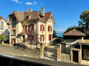 a large house with red windows on a street at Bellavista in Neuchâtel