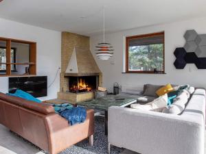 a living room with two couches and a fireplace at 14 person holiday home in Sjællands Odde in Tjørneholm