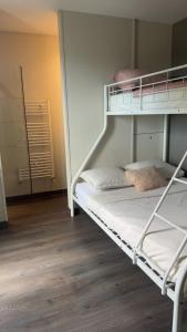 an empty bunk bed in a room with wooden floors at LA VILLa in La Rochelle