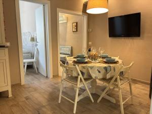 ein Esszimmer mit einem Tisch mit Stühlen und einem TV in der Unterkunft Piano terra con giardino, vicino al mare in Viareggio
