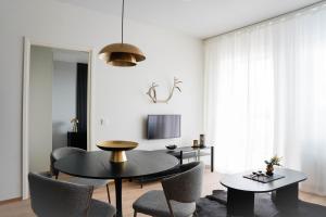 ein Wohnzimmer mit 2 Tischen und Stühlen sowie einem TV in der Unterkunft Premium Apartment With Sauna & Parking - Lapnest in Rovaniemi