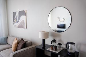ein Wohnzimmer mit einer Couch und einem Spiegel in der Unterkunft Premium Apartment With Sauna & Parking - Lapnest in Rovaniemi
