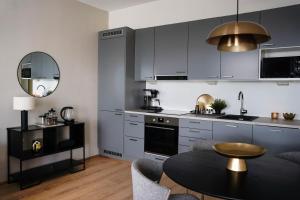 eine Küche mit grauen Schränken und einem Tisch mit einem Tisch in der Unterkunft Premium Apartment With Sauna & Parking - Lapnest in Rovaniemi