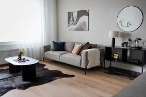 ein Wohnzimmer mit Couch und Tisch in der Unterkunft Premium Apartment With Sauna & Parking - Lapnest in Rovaniemi