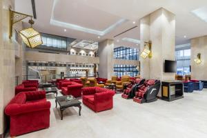 a lobby with red couches and chairs at Razana Al Rawdha Hotel in Makkah