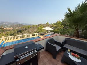 a balcony with a table and chairs and a pool at Villa Arturo Tossal Gross in La Font D´En Carròs