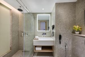 a bathroom with a sink and a glass shower at Riviera Sarovar Portico Pathankot in Pathānkot +45 photos