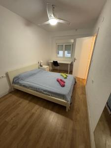 a bedroom with a bed with a blue comforter at Paseo marítimo ALMERIA RL in Almería