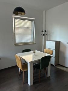 una mesa blanca y sillas en una habitación con nevera en Ohrid Apartment, en Ohrid