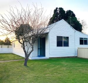 a white house with a tree in a yard at Longford Cottage in Longford
