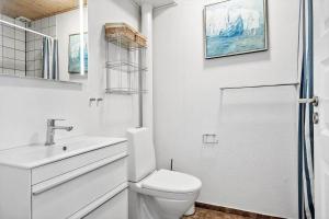 a white bathroom with a toilet and a sink at 4135-Borre-Klintholm-Havneby-35-st in Borre +18 photos
