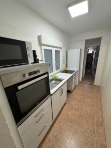a kitchen with a sink and a microwave at Paseo marítimo ALMERIA RL in Almería