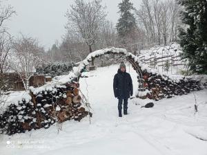 a person walking through a snow covered archway at Chalet des fontaines claires in Aydat