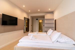 a bedroom with two beds and a flat screen tv at Luxury Rooms Terrazza Sette in Split