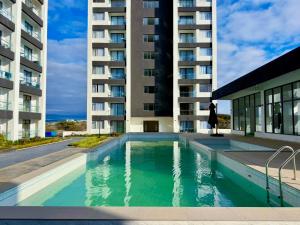 a swimming pool in front of a building at Chic Retreat Near JKIA and SGR with Nairobi National Park Views in Nairobi