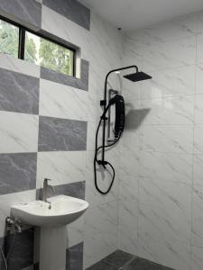 a bathroom with a shower head and a sink at Pandan Hotel in Papar