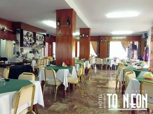 a dining room with green tables and chairs at To NEON in Loutra Ipatis