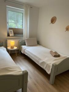 a bedroom with two beds and a window at Ferienwohnung II im idyllischen Gulfhof in Krummhörn