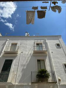 ein weißes Gebäude mit Kleidung davor in der Unterkunft Dimora Immacolata in Castellana Grotte