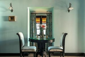 Fort Tiracol Heritage Hotel في أرامبول: غرفة طعام مع طاولة وكرسيين ونافذة