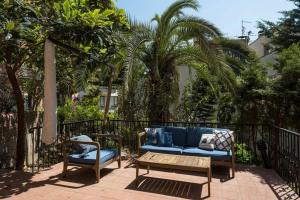a blue couch and chairs on a balcony with palm trees at Beautiful Modern Bright 2bd Patio Duplex #179 in Istanbul