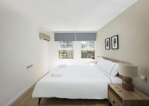 a bedroom with a large white bed and two windows at Beautiful Modern Bright 2bd Patio Duplex #179 in Istanbul