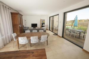 Una sala de estar con una mesa y sillas y un sofá. en La floridienne, en La Cassagne